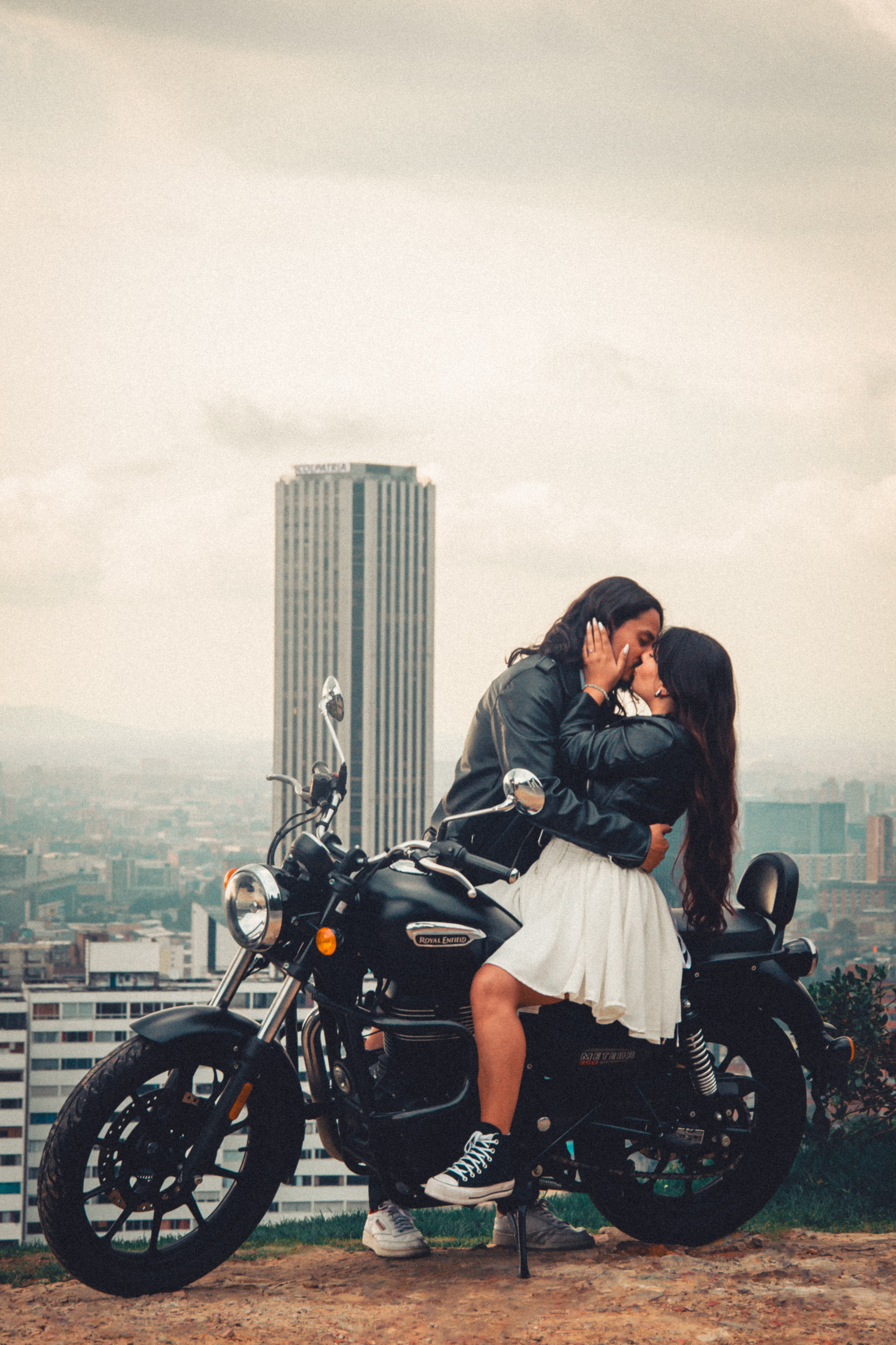 A couple in a motorcycle with a sunset in the background